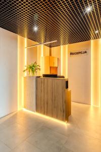 a lobby with a reception desk with a potted plant at ApartHotel S8 - Apartamenty Wrocław in Wrocław