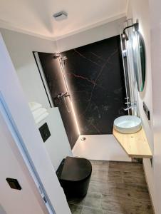 a bathroom with a black toilet and a sink at Jagdhotel am Strehlesee in Wandlitz