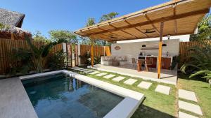 a backyard with a swimming pool and a wooden pergola at Villa Nindot - Private pool villas - Adults only in Siquijor