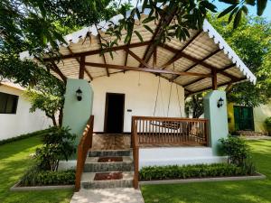 a house with a pergola in the yard at Daksh Resort And Amusement Park in Sasan Gir