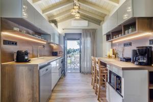 a large kitchen with wooden floors and white cabinets at Luxury Villa with Private Pool in Skopelos, Nature Retreat, Villa Pine Trees by Kardous in Alikias