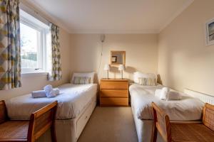 a bedroom with two beds and a window at West Cottage - Elie in Earlsferry