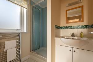 a bathroom with a sink and a glass shower at West Cottage - Elie in Earlsferry