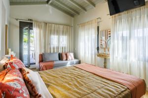 a bedroom with a bed and a couch and a window at Luxury Villa with Private Pool in Skopelos, Nature Retreat, Villa Pine Trees by Kardous in Alikias