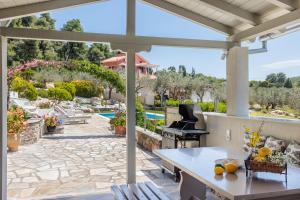 a patio with a table and a grill and a pool at Luxury Villa with Private Pool in Skopelos, Nature Retreat, Villa Pine Trees by Kardous in Alikias
