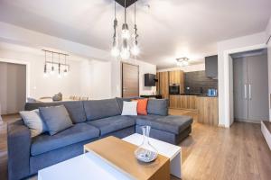 a living room with a blue couch and a kitchen at Athenean Pool Break in Athens