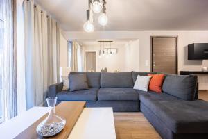 a living room with a blue couch and a table at Athenean Pool Break in Athens