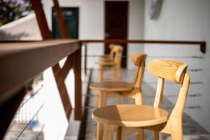 a couple of wooden chairs sitting next to a counter at Sinai Rimtalay Hotel in Ban Nong Sanom