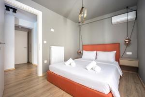 a bedroom with a large bed with white sheets at Athenean Pool Break in Athens +22 photos