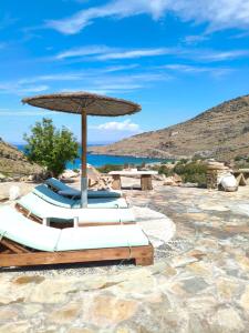 a group of lounge chairs under an umbrella on the beach at Sun Holiday Kea Private Pool Sea View in Pisses