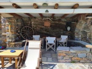 a patio with a table and chairs and a wheel at Sun Holiday Kea Private Pool Sea View in Pisses