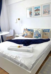 a bedroom with a large white bed with towels on it at Zen Studio Olimp Poolside in Olimp +45 photos