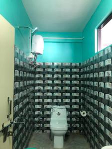 a bathroom with a toilet and a green wall at Fable homestay in Pedong