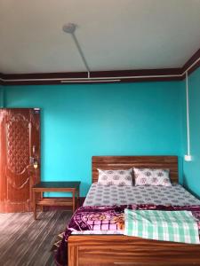 a bedroom with a bed with a blue wall at Fable homestay in Pedong