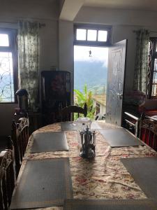 a dining room with a table and a window at Fable homestay in Pedong