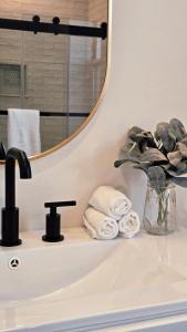a bathroom sink with a mirror and a vase of towels at Fox Point Landing Residences in Providence +62 photos