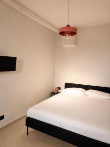 a bedroom with a white bed and a tv at Giuditta Room C in Ciriè