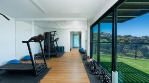 an empty gym with a large window and tread machines at Villa Skylark - by LovelyStay in Ponta do Sol