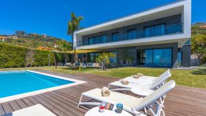 a villa with a swimming pool and a house at Villa Skylark - by LovelyStay in Ponta do Sol