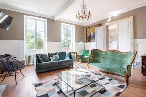 a living room with a couch and a glass table at Maison de famille au coeur de son vignoble in Lorignac
