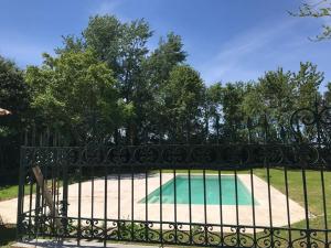 a black iron fence with a golf course behind it at Maison de famille au coeur de son vignoble in Lorignac