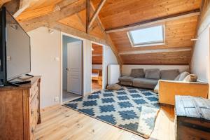 a living room with a couch and a television at Maison de famille au coeur de son vignoble in Lorignac