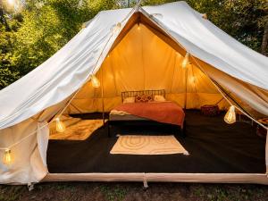 a canvas tent with a bed in it at Glamping Hive by Stream in Víska +54 photos