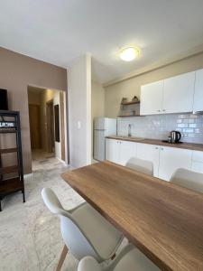 a kitchen with a wooden table and white cabinets at Olympic Beach Rooms in Olympic Beach