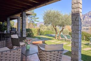 a patio with a table and chairs and a garden at Villa Vittoria with private heated pool & shared sauna - Bellagio Village Residence in Oliveto Lario