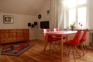 a dining room with a table and red chairs at Villa am Oberpfuhl in Lychen