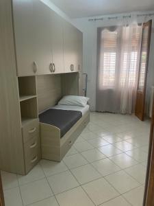 a bedroom with a bed and a cabinet and a window at La Capaciota in Capaci