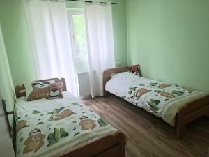 two twin beds in a room with green walls at Drina's Heart in Bajina Bašta