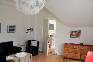 a living room with a chandelier and a dresser at Villa am Oberpfuhl in Lychen
