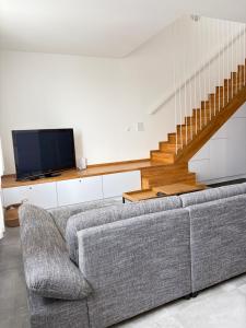 a living room with a couch and a tv at Apartament MALIN in Mrągowo