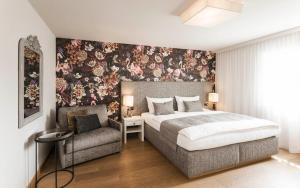 a bedroom with a bed and a chair at Schenna Chalet - Chalet Oasis in Schenna