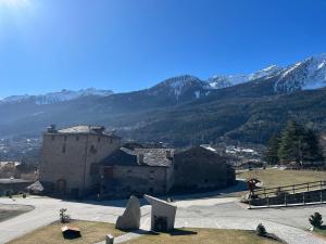 a large building with mountains in the background at La Breila Morgex in Morgex