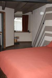 a bedroom with a red bed and a window at La Breila Morgex in Morgex