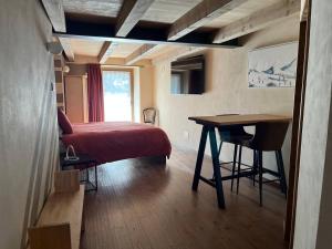 a bedroom with a bed and a desk and a table at La Breila Morgex in Morgex