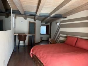 a bedroom with a red bed and a table at La Breila Morgex in Morgex