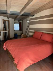 a bedroom with a large red bed in a room at La Breila Morgex in Morgex +17 photos