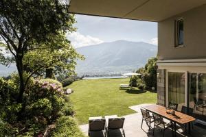 a patio with a table and chairs on a lawn at Schenna Chalet - Chalet Oasis in Schenna
