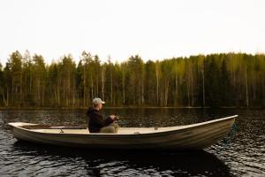 a man sitting in a boat on a lake at Kyyrönkaita in Kyyrö +114 photos