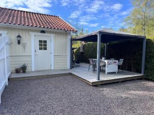 a patio with a table and an umbrella at Mysig lägenhet med morgondopp in Uppsala