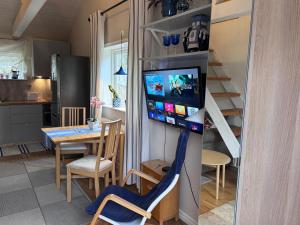 a kitchen and dining room with a television on a wall at Mysig lägenhet med morgondopp in Uppsala