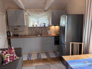 a kitchen with a stainless steel refrigerator and a table at Mysig lägenhet med morgondopp in Uppsala +7 photos