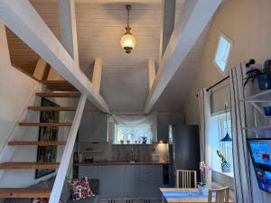 a kitchen with a staircase in a tiny house at Mysig lägenhet med morgondopp in Uppsala