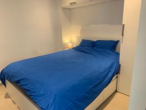 a bed with a blue comforter in a bedroom at Les Terrasses de Malmedy 22 Studio 341 in Malmedy
