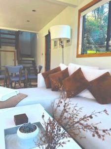 a living room with a bed and a table with a bowl of grapes at Ecoasis Mami Wata in Uki +116 photos