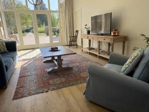 a living room with a couch and a table and a tv at Owl Barn in King's Lynn