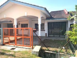 an orange gate in front of a house at Bertam Transit Homestay in Kampong Alor